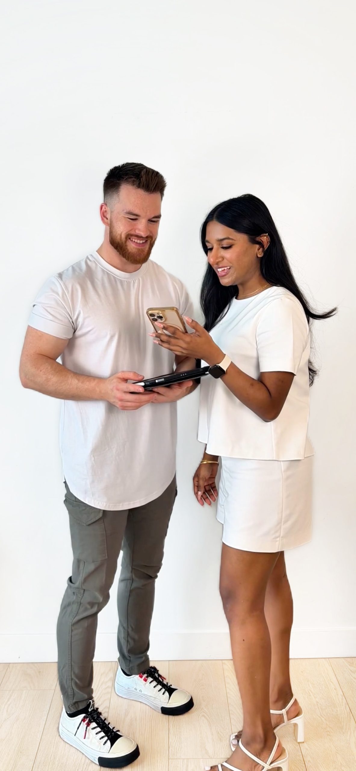 Two Hello Search Marketing team members checking new Google reviews on a phone